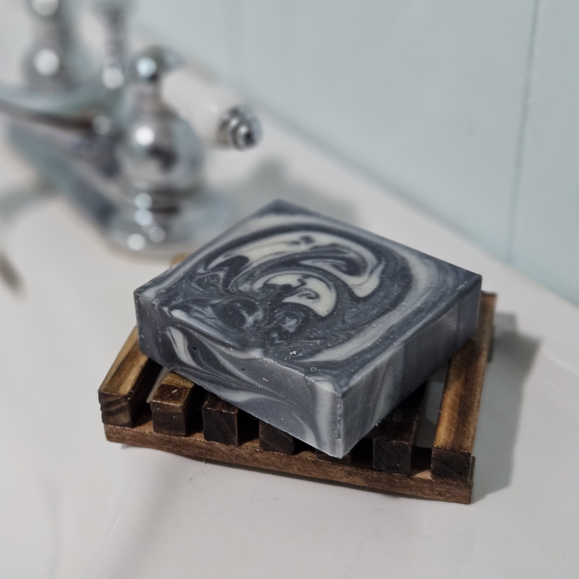 Charcoal Cleanse soap bar on soap saver dish beside sink