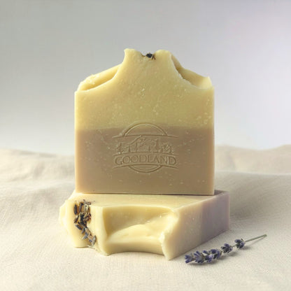 Two bars of Goodland soap with lavender on a light fabric background