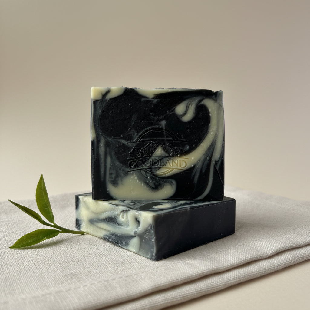 Two bars of black and white soap with 'Goodland' branding on a light gray background