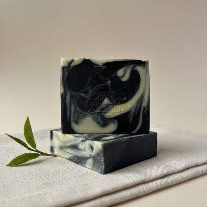 Two bars of black and white soap with 'Goodland' branding on a light gray background